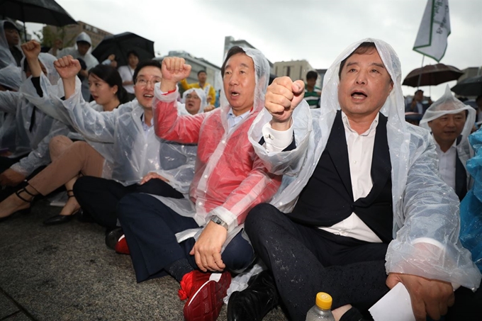 김병준(맨 오른쪽부터) 자유한국당 비상대책위원장과 김성태 원내대표가 29일 서울 광화문광장에서 열린 소상공인 생존권 운동연대 주최 ‘최저임금 제도개선 촉구 국민대회’에 참석해 구호를 외치고 있다. 뉴스1