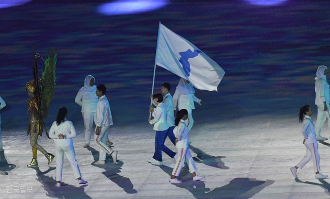 [저작권 한국일보] 2일 오후(현지시간) 인도네시아 자카르타 겔로라 붕 카르노(GBK) 메인스타디움에서 열린 2018 자카르타-팔렘방 아시안게임 폐막식에서 남측 기수 서효원과 북측 기수 최일이 한반도기를 들고 공동입장하고 있다.인도네시아 자카르타=서재훈기자