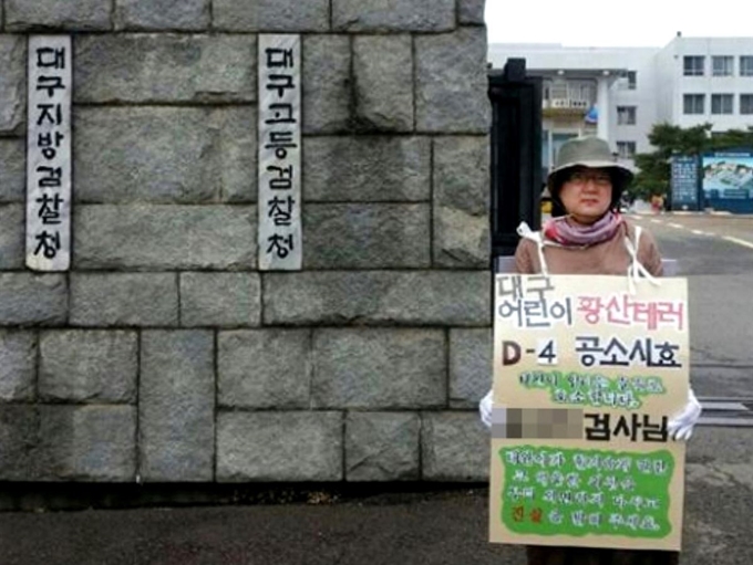 대구 황산테러 사건으로 숨진 김태완군의 어미니 박정숙씨가 2014년 7월 대구지검 앞에서 살인죄 공소시효 폐지를 요구하는 1인 시위를 하는 사진. 김태완군의 사건을 계기로 2015년 살인죄 공소시효는 폐지됐다. 박정숙씨 제공. 한국일보 자료사진.