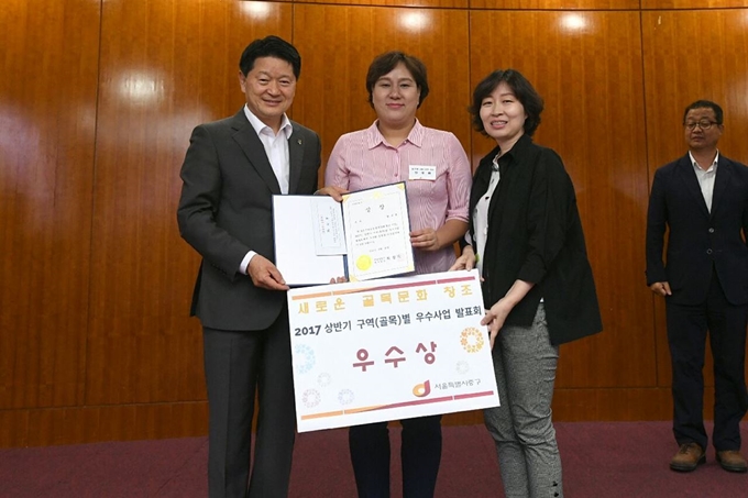 안영희(가운데)씨가 지난해 ‘중구 상반기 구역(골목)별 우수사업 발표회’에서 우수상을 수상한 뒤 최창식(왼쪽) 당시 중구청장과 기념 촬영을 하고 있다. 서울시 제공