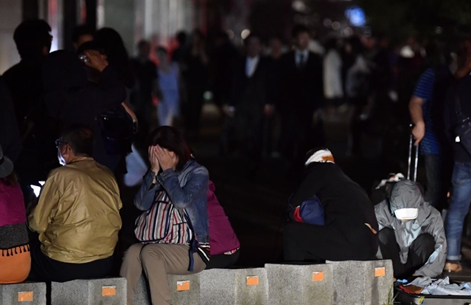 일본 홋카이도 남쪽에서 6일 새벽 3시 8분께 규모 6.7의 지진이 발생했다. 사진은 이날 지진으로 정전이 발생한 삿포로 시내에서 시민들이 피곤한 모습으로 길가에 앉아 있는 모습. 삿포로=교도 연합뉴스