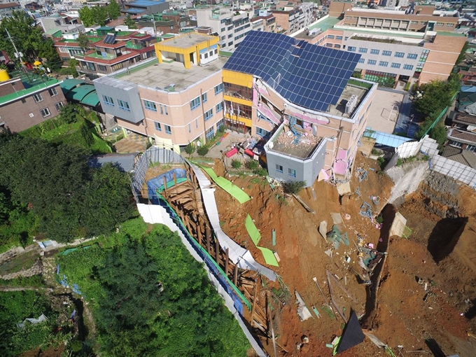 7일 오전 서울 동작구 상도초등학교 내 상도유치원이 인접 공사장 흙막이 붕괴로 기울어져 붕괴위험에 처해있다. 6일 밤 서울 동작구의 한 공동주택 공사 현장에서 흙막이가 붕괴되며 지반이 침하돼 인근 상도초등학교 내 유치원 건물이 기울어지는 사고가 발생했다. 동작소방서는 이날 오후 11시22분쯤 신고를 접수하고 동작구청 등과 함께 현장을 통제하고 있다고 밝혔다. 뉴스1