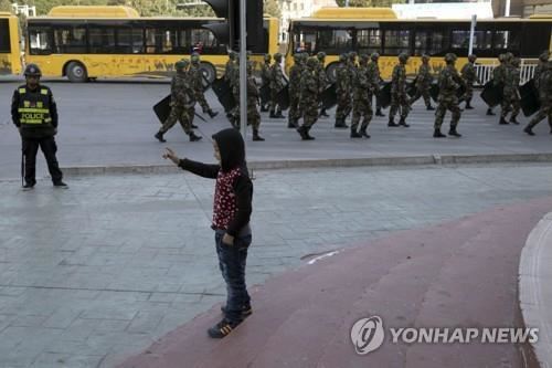 신장위구르의 한 지역에서 보안요원들이 행렬을 지어 순찰하는 모습. AP=연합뉴스