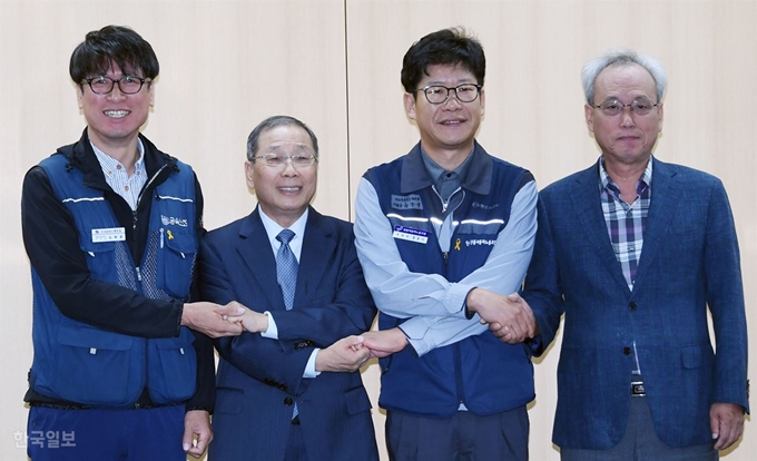 14일 오전 서울 광화문 경제사회노동위 대회의실에서 열린 쌍용차 노사 해고자 복직 잠정 합의 발표에서 김득중 쌍용차지부장(왼쪽부터), 최종식 쌍용자동차 사장, 홍봉석 쌍용자동차 노조위원장, 문성현 경제사회노동위원장이 손을 맞잡고 기념촬영을 하고 있다. 신상순 선임기자