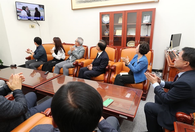 민주평화당 의원 및 당직자들이 18일 오전 국회에서 문재인 대통령 평양 순안공항에 도착한 방송을 시청하며 박수치고 있다. 연합뉴스