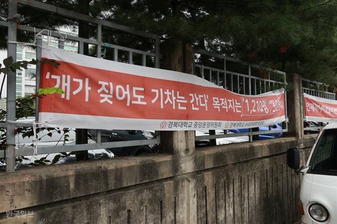 [저작권 한국일보]대구 북구 경북대 대구캠퍼스 울타리에 임대업자들의 실력행사에 굴복해 기숙사 수용인원을 줄이겠다고 한 대학본부의 처사를 비난하는 현수막이 내걸려 있다. 정광진기자 kjcheong@hankookilbo.com