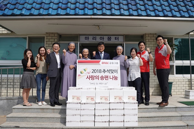 BNK금융그룹이 추석을 앞두고 18일 주변 어려운 이웃을 위해 ‘사랑의 송편 나눔’행사를 실시했다.(사진 왼쪽서 여섯 번째는 BNK금융지주 최홍영 그룹경영지원총괄부문장)