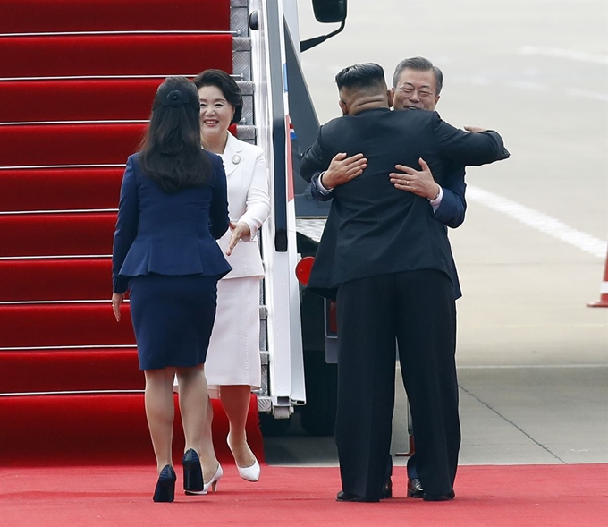 문재인 대통령과 부인 김정숙 여사가 18일 오전 평양 순안공항에 도착한 뒤 마중 나온 김정은 국무위원장과 부인 리설주 여사와 인사하고 있다. 평양=사진공동취재단