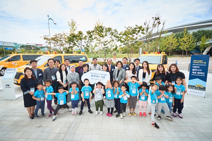 18일 경기 고양시 현대모터스튜디오 고양에서 현대차측이 스타렉스 통학차량 14대를 어린이집 및 지역아동센터에 기증한 후 기념촬영을 진행하고 있다. 현대차 제공