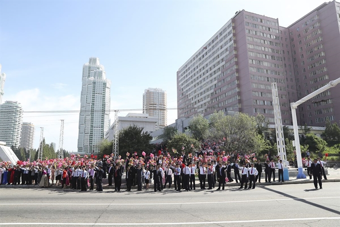 18일 평양 순안공항에서 평양시내로 향하는 거리에 시민들이 꽃을 흔들며 문재인 대통령을 환영하고 있다. 평양사진공동취재단