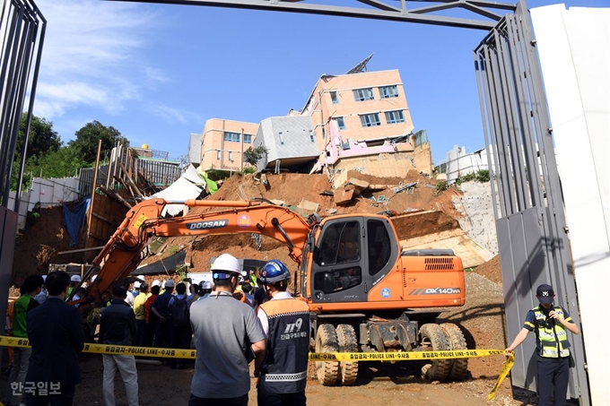 [저작권 한국일보] 소방관계자들이 다세대주택 공사장의 흙막이가 무너져 내린 7일 오전 서울 동작구 상도동 상도유치원 건물과 관련해 이야기를 나누고 있다. 고영권 기자