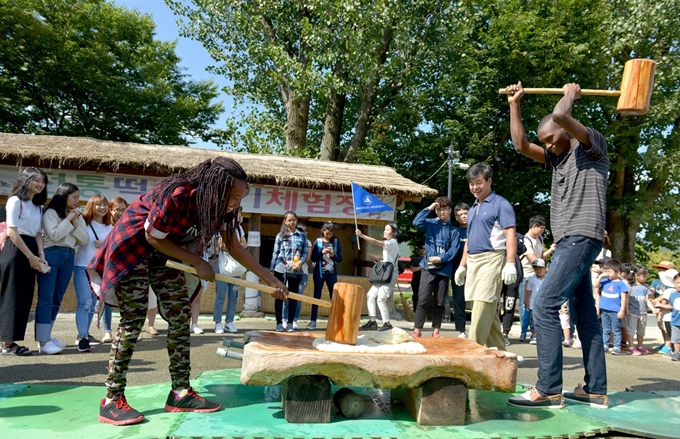 추석을 맞아 한국문화체험에 나선 백석대 외국인 학생들이 19일 충남 아산시 외암민속마을에서 떡메를 내리치고 있다. 백석대 제공