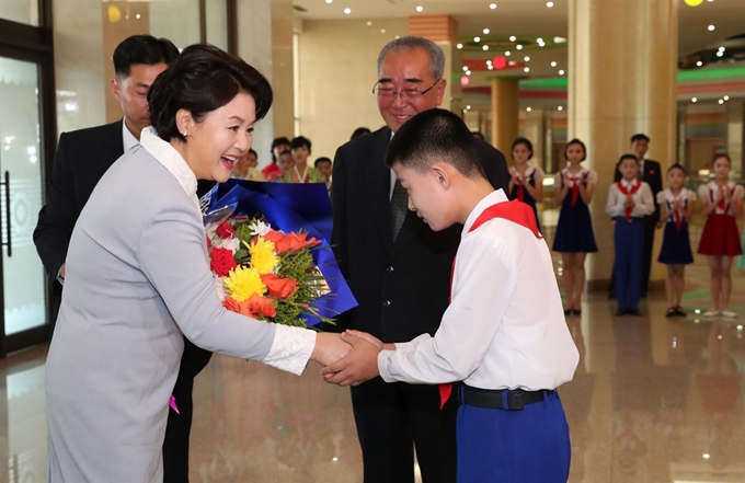 김정숙 여사가 19일 오전 만경대 학생소년궁전을 방문해 렴윤학 총장과 학생으로부터 꽃다발을 받고 인사를 나누고 있다. 평양사진공동취재단