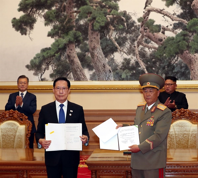 송영무(왼쪽) 국방부 장관과 노광철 북한 인민무력상이 군사분야 합의서에 서명을 마친 뒤 합의문을 들어 보이고 있다. 촬영 전 노 인민무력상은 서명된 페이지를 찾는 듯 4~5초 동안 합의서를 뒤적여 웃음을 자아냈다. 평양사진공동취재단