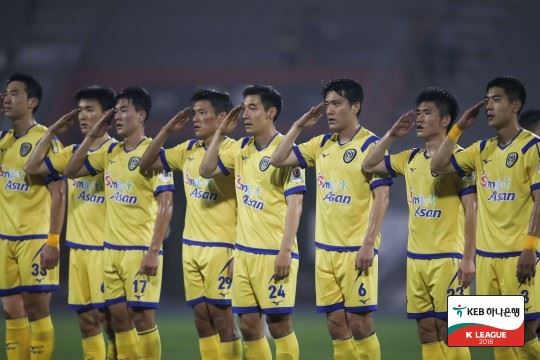 아산무궁화 축구단이 올해부터 선수 선발을 하지 않기로 결정하면서 프로축구계가 혼란에 빠졌다. 사진은 아산 선수들이 거수 경례하는 모습. 프로축구연맹 제공