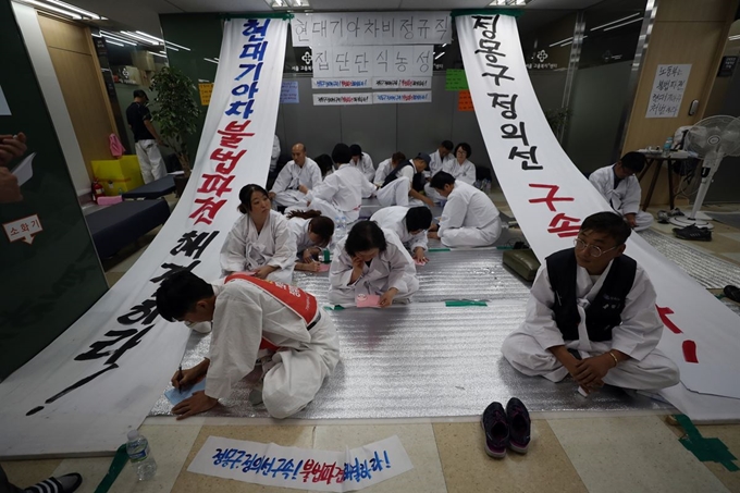 지난 23일 오후 중구 장교동 서울고용노동청에서 단식 농성 중인 현대·기아차 비정규직 노동자들이 추석을 맞아 가족에게 손편지를 쓰고 있다. 연합뉴스