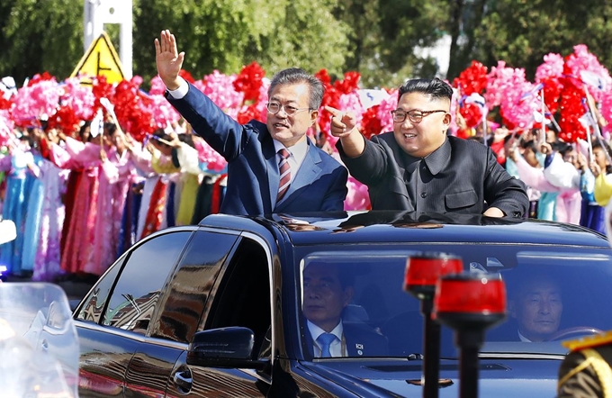 문재인 대통령이 제3차 남북정상회담 첫날인 18일 평양 순안공항에서 백화원 초대소로 이동하는 중간 김정은(오른쪽) 북한 국무위원장과 무개차를 함께 타고 환영 나온 평양 시민들에게 인사하는 카퍼레이드를 하고 있다. 평양=사진공동취재단