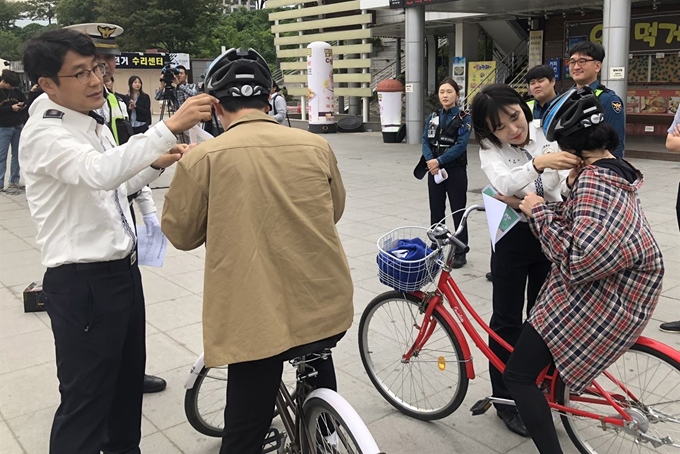 개정된 도로교통법이 시행된 28일 서울 여의도 한강공원에서 경찰이 자전거 운전자를 대상으로 안전모 착용 계도활동을 하고 있다. 이날부터 도로법상 도로와 자전거도로를 이용하는 모든 자전거 운전자와 동승자에게 안전모 착용이 의무화된다. 다만 이는 훈시규정이어서 처벌은 없다. 연합뉴스