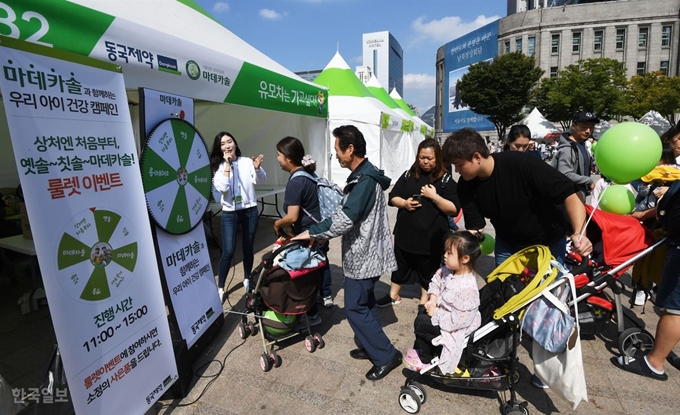 어린이 안전캠페인 '유모차는 가고 싶다' 행사가 30일 서울 시청 앞 서울광장에서 열린 가운데 참가자들이 기념품을 받기 위해 줄지어 서 있다. 홍인기 기자