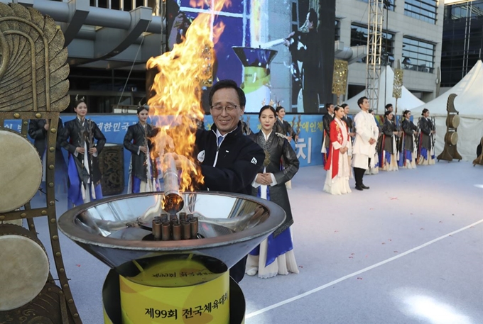 송하진 전북도지사가 지난 3일 전북도청 광장에서 열린 제99회 전국체전과 제 38회 전국장애인체전 성화 안치식에서 이날 강화도 마니산에서 채화해 도착한 성화를 성화로에 점화하고 있다. 전북도 제공