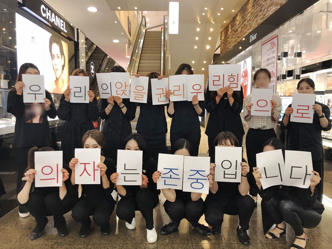 백화점 판매직 노동자들이 29일 영업 개시 직전 한자리에 모여 스스로 ‘앉을 권리’를 찾겠다는 내용의 문구를 들어 보이고 있다. 1일 시작된 ‘의자 앉기 공동 행동’을 앞두고 결의를 다지는 차원에서 촬영한 ‘인증샷 사진이다. 비슷한 시기 백화점과 면세점 등 전국의 유통사업장에서도 ‘인증샷 결의’가 이어졌다. 고객과 유통사에 치여 약자 취급을 받아 온 판매직 노동자들은 앞으로 ‘앉을 권리’와 함께 ‘쉴 권리’, ‘존중받을 권리’를 찾기 위한 행동을 이어갈 계획이다. 민주노총 서비스연맹 제공