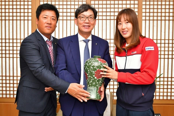 한국 여자 테니스 간판 최지희(오른쪽)와 김동현(왼쪽) 감독이 1일 서울 서대문구 NH농협은행 사옥에서 이대훈(가운데) 은행장에 트로피를 전하고 있다. NH농협은행 제공