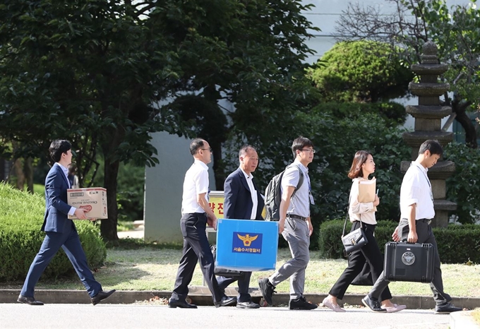 지난달 5일 서울 강남구 숙명여고를 압수수색한 서울 수서경찰서 직원들이 압수물을 담은 상자를 들고 학교를 나서고 있다. 연합뉴스