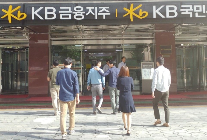 캐주얼 차림의 KB금융지주, KB국민은행 직원들이 4일 오전 서울 여의도에 위치한 본사 건물로 들어가고 있다. KB금융은 그간 금요일에 한해 실시되던 근무복장 자율착용을 지난달부터 전일로 확대해 시행하고 있다. KB금융 제공