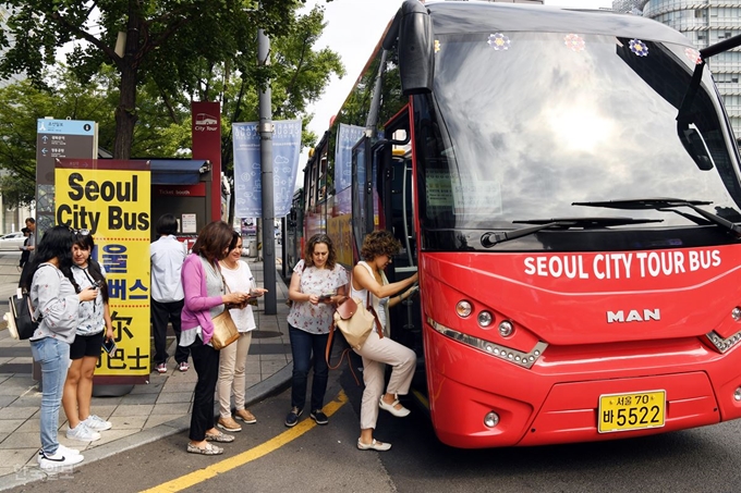 외국인 관광객들이 지난달 18일 서울 광화문 한국금융사박물관 앞 정류장을 출발하는 서울시티투어버스 도심고궁 노선에 오르고 있다. 고영권 기자