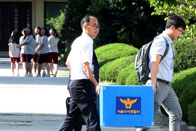 5일 오후 서울 강남구 숙명여고에서 경찰이 이 학교 교무부장이 2학년인 쌍둥이 딸 2명에게 시험 문제를 유출해 성적을 올렸다는 의혹과 관련해 압수수색을 마친 뒤 자료를 가지고 나가고 있다. 뉴시스