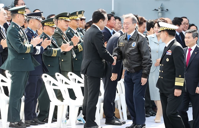 문재인 대통령이 11일 오후 제주특별자치도 서귀포시 제주민군복합형 관광미항 앞바다에서 열린 2018 대한민국 해군 국제 관함식 참관을 위해 '좌승함(座乘艦)'인 상륙함 '일출봉함'에 마련된 행사장에 입장하며 참석자들과 인사를 나누고 있다. 오른쪽은 정경두 국방부 장관. 연합뉴스