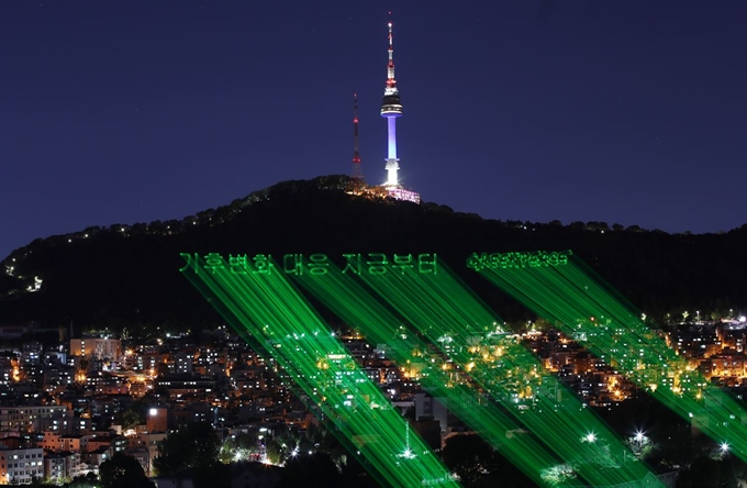 지난달 30일 밤 서울 중구 남산 N서울타워 아래로 '기후변화 대응 지금부터'라고 적힌 메시지가 레이저빔으로 표시되고 있다. 국제환경단체 그린피스 서울사무소는 1일부터 인천 송도에서 열린 '기후변화에 관한 정부 간 협의체(IPCC)' 제48차 총회 개막일에 맞춰 국내 공적 금융 기관들의 해외 석탄발전소 금융지원 중단을 촉구하는 깜짝 레이저빔 퍼포먼스를 펼쳤다. 연합뉴스