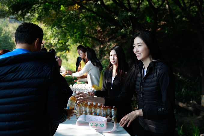 13일 오전 서울 중구 남산 백범광장에서 열린 제478회 한국일보 거북이마라톤 ‘2018 비만예방의 날 기념 남산 걷기대회’에서 2018 미스코리아들이 시민에게 음료를 전달하고 있다. 추진혁 기자.