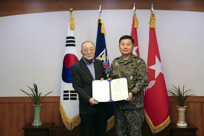 지난 8일 육군사관학교 운주당에서 열린 육사발전기금 출연행사에서 육사 44기 고(故) 이상엽 소위의 부친인 이승우(왼쪽) 옹이 31년간 모아온 아들의 유족연금 1억 원을 전달하고 있다. 육군 제공