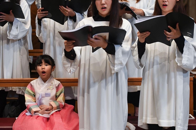 바티칸의 성 베드로 대성당에서 17일(현지시간) 교황청을 공식 방문 중인 문재인 대통령이 참석한 '한반도 평화를 위한 특별미사' 가 열려 한복을 곱게 차려 입은 한 소녀가 합창단과 함께 노래를 부르고 있다. EPA 연합뉴스