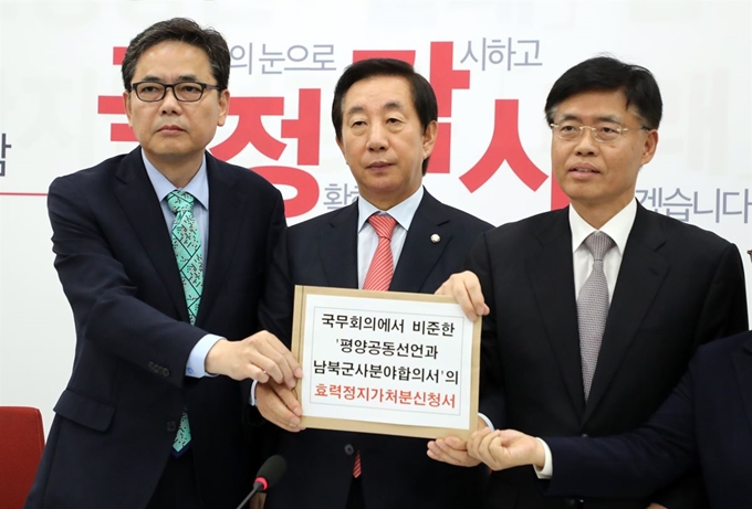 김성태(가운데) 자유한국당 원내대표가 24일 국회 원내대표실에서 곽상도 최교일 의원과 함께 긴급 기자회견을 하며 '국무회의에서 비준한 평양공동선언과 남북군사합의서의 효력정지가처분 신청서'를 들어보이고 있다. 연합뉴스