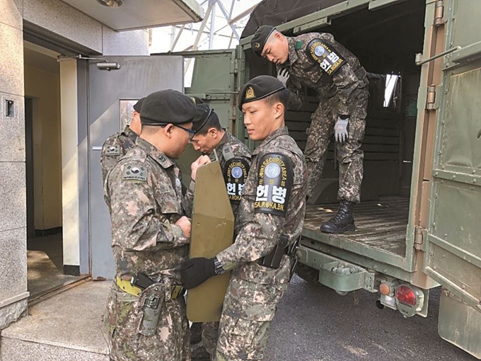 우리 군 장병들이 25일 판문점 공동경비구역(JSA) 내 초소를 비우기 위해 초소 내 방호 장비를 군 차량에 싣고 있다. 이날 남북 군사당국과 유엔군사령부는 남북 군사분야 합의서에 명시된 ‘JSA 비무장화’를 위해 남북 측 초소에서 철수하고 화기와 탄약 등도 밖으로 옮겼다. 국방부 제공