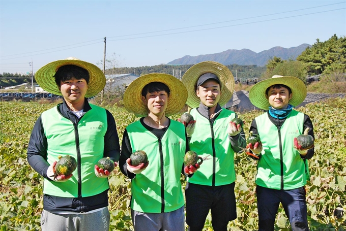 금호산업 직원들이 충북 증평군 증평읍 사곡리 마을에서 호박을 딴 뒤 포즈를 취하고 있다. 금호산업 제공