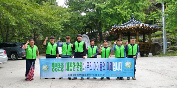 금호산업 직원들이 경북 의성군 금성산 등산로에서 환경정화활동을 하기 전 기념촬영을 하고 있다. 금호산업 제공