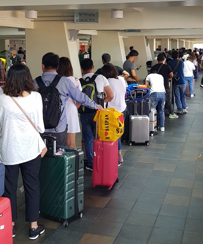 28일 오전 슈퍼 태풍 '위투'가 지나간 사이판 공항 군용헬기 접수장에서 여행객들이 출국 수속을 기다리고 있다. 독자 제공=연합뉴스