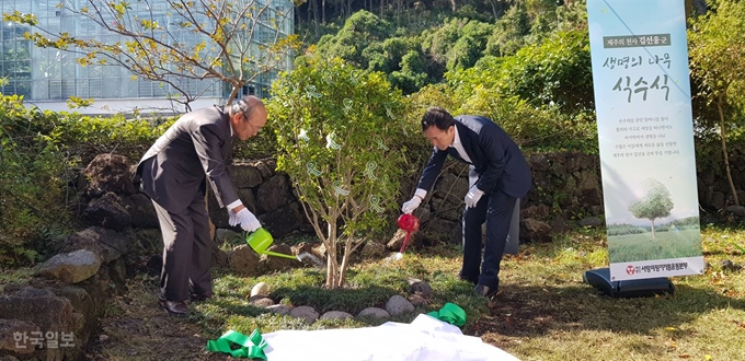 [저작권 한국일보]고 김선웅 군을 기리는 '생명에 나무'에 물을 주는 김군의 아버지 김형보씨(오른쪽)와 박진탁 사랑의장기기증운동본부 이사장. 김영헌 기자.