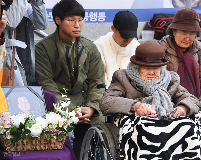 [저작권 한국일보] 31일 종로구 주한일본대사관 앞에서 열린 일본군 위안부 피해자 문제 해결 촉구 수요집회에 참석한 이옥선 할머니가 지난 26일 별세한 고 하점연 할머니의 영정 옆에서 묵념을 하며 고인의 넋을 기리고 있다. 류효진 기자 /2018-10-31(한국일보)