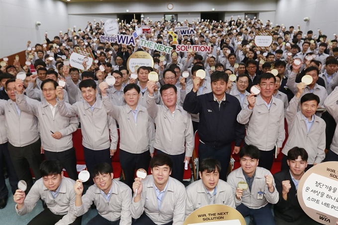 김경배 현대위아 사장(두번째 줄 오른쪽 네번째)과 손성환 현대위아 노동조합 지회장(두번째 줄 오른쪽 세번째) 등 현대위아 임직원들이 1일 경남 창원시 성산구 현대위아 본사 대강당에서 열린 '비전 결의 대회'에서 각자의 미래 비전을 적은 '비전카드'를 들어 보이고 있다. 현대위아 제공