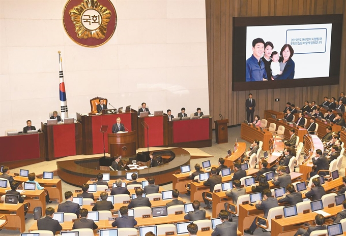 문재인 대통령이 1일 국회 본회의장에서 시정연설을 하고 있다. 문 대통령 옆으로 4인 가족의 사진이 담긴 프레젠테이션(PT) 자료가 대형 스크린 화면에 띄워져 있다. 류효진 기자