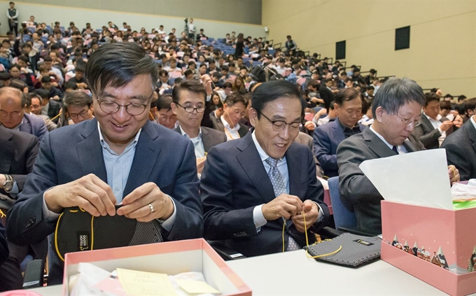 1일 오후 경기 수원시 삼성디지털시티에서 열린 삼성전자 창립 49주년 기념식에서 김기남(앞줄 가운데) 대표이사 사장을 비롯한 임직원들이 어려운 이웃에게 전달할 방한용품 세트를 만들고 있다. 삼성전자 제공