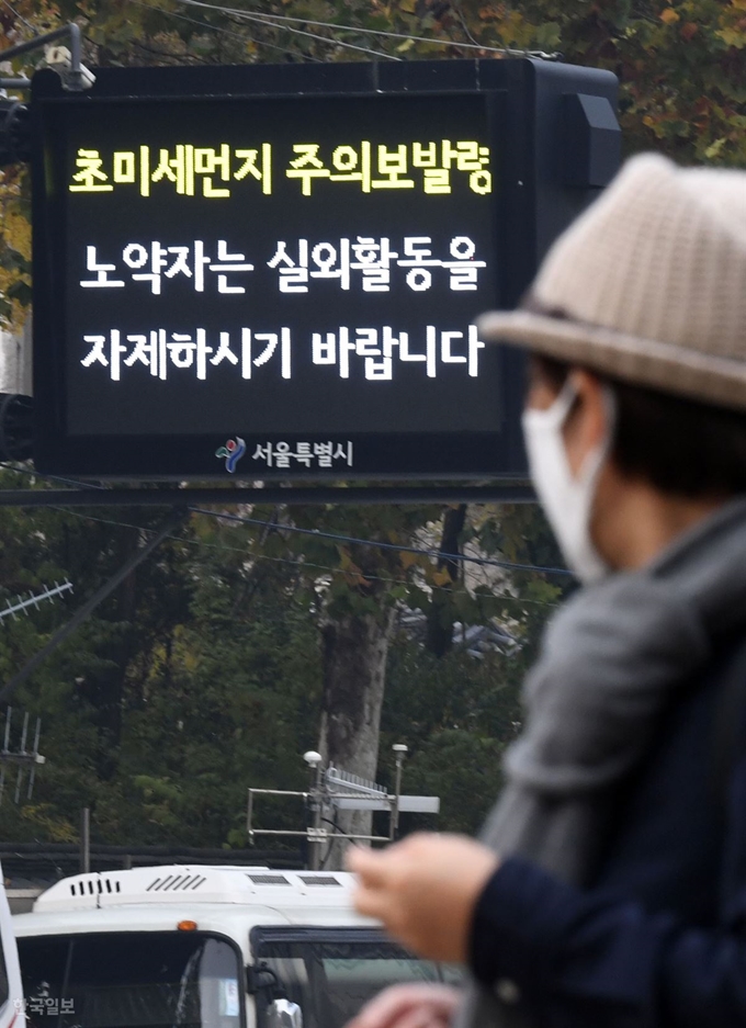 전국 곳곳에 초미세먼지 주의보가 발령된 6일 오후 서울시청 인근에서 마스크를 쓴 시민이 노약자의 실외활동 자제를 알리는 전광판을 바라보고 있다. 신상순 선임기자