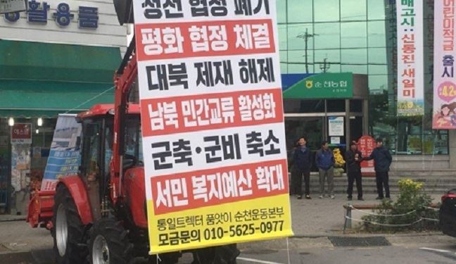 통일트랙터 품앗이 순천운동본부 관계자가 통일트랙터 시승식을 하고 성금을 독려하고 있다.