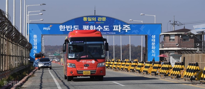 [저작권 한국일보]. 20여명의 관광객을 태운 파주시티투어버스가 1박2일의 평화 안보 코스를 여행한 뒤 4일 오후 경기 파주시 통일대교 남단을 빠져 나오고 있다. 북한군의 침투를 막기 위해 쳐놓은 철조망과 겹겹이 설치된 바리게이드가 분단의 현실을 보여준다. 류효진 기자