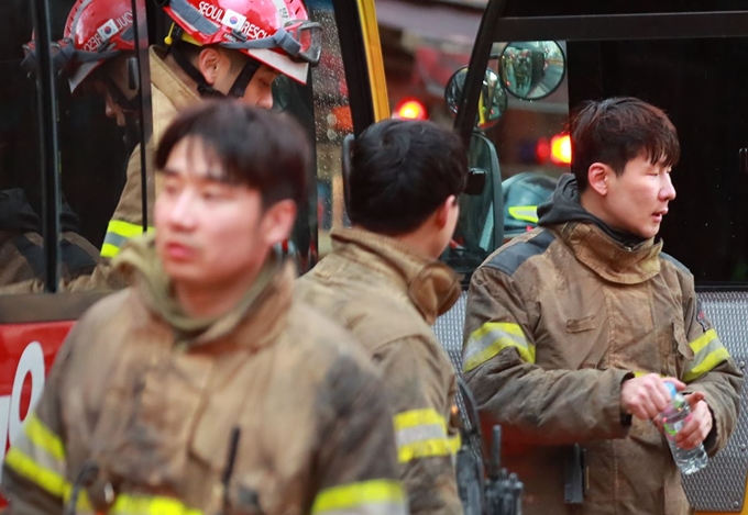 9일 오전 화재가 발생한 서울 종로구 관수동의 한 고시원에서 화재 진압을 마친 소방대원들이 물을 마시며 한숨을 돌리고 있다. 연합뉴스