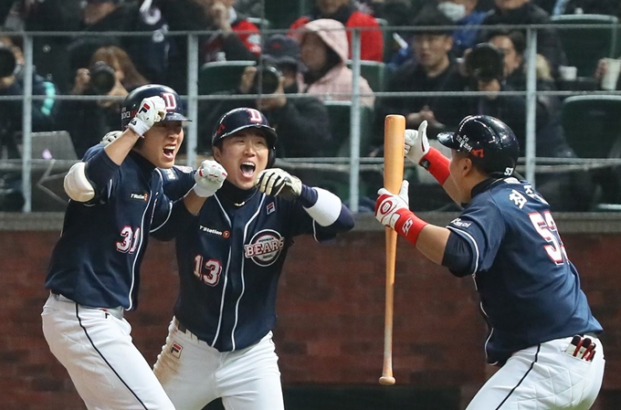 정수빈(왼쪽)이 9일 인천 SK행복드림구장에서 열린 2018 프로야구 한국시리즈 4차전에서 8회 역전 투런 홈런을 때린 뒤 허경민(가운데), 최주환과 환호하고 있다. 인천=연합뉴스.